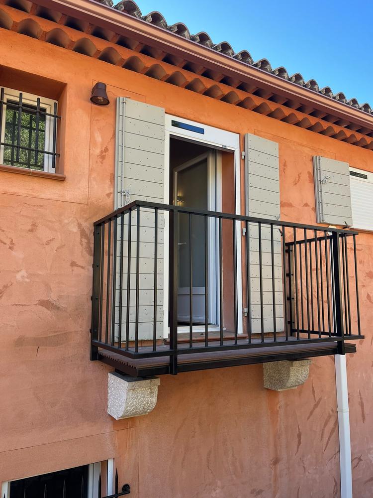 Porte-fenêtre avec volet roulant et volets battants, donnant sur un balcon